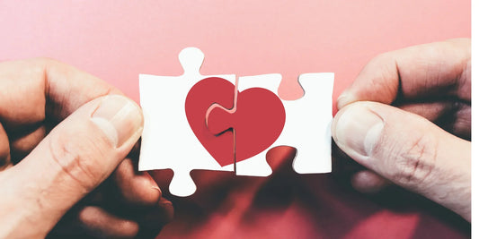 Hand holding heart jigsaw puzzle piece